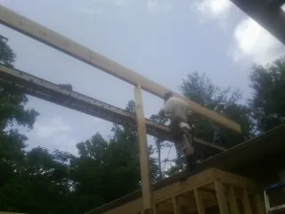 Carpenter setting a ridge beam over a new addition frame — Ice Dam Removal by Roofing Brothers in Fort Loudon