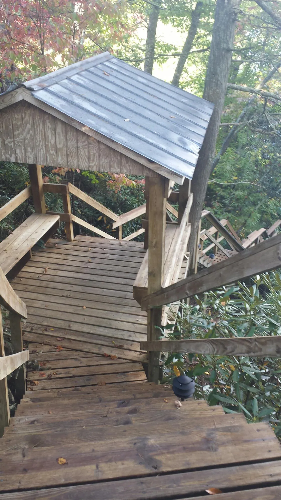 Metal roofed shelter over wooden steps on a wooded walkway — Skylight Repair & Installation work by our crew in Fort Loudon