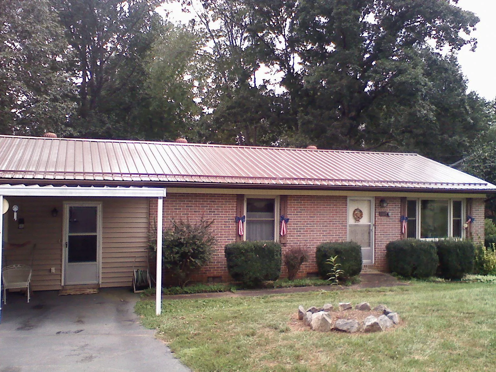 Bronze metal roof and carport on a brick ranch home — Roof Repair work by our crew in Fort Loudon